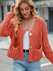 Chunky knit cardigan in orange with gold buttons and patch pockets.