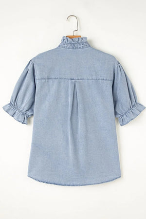 Light blue denim blouse with ruffled collar, puff sleeves, and button front.