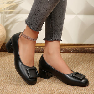 Black buckle block heel shoes with a square toe detail.