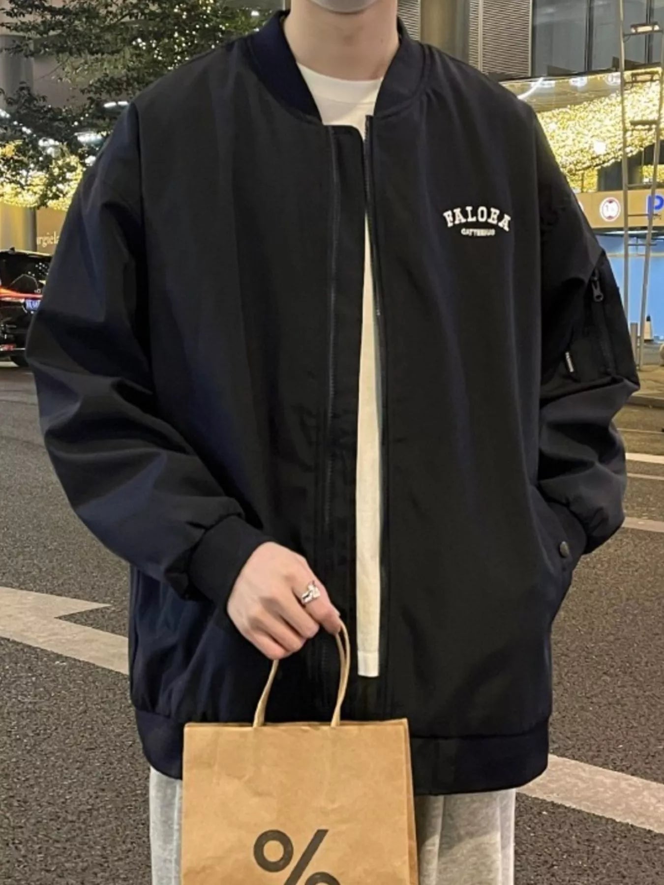 Black bomber jacket with zip front, embroidered logo on chest, and zippered sleeve pocket.