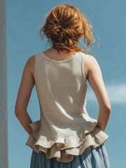 Off-white sleeveless tank top with a ruffled hem detail.
