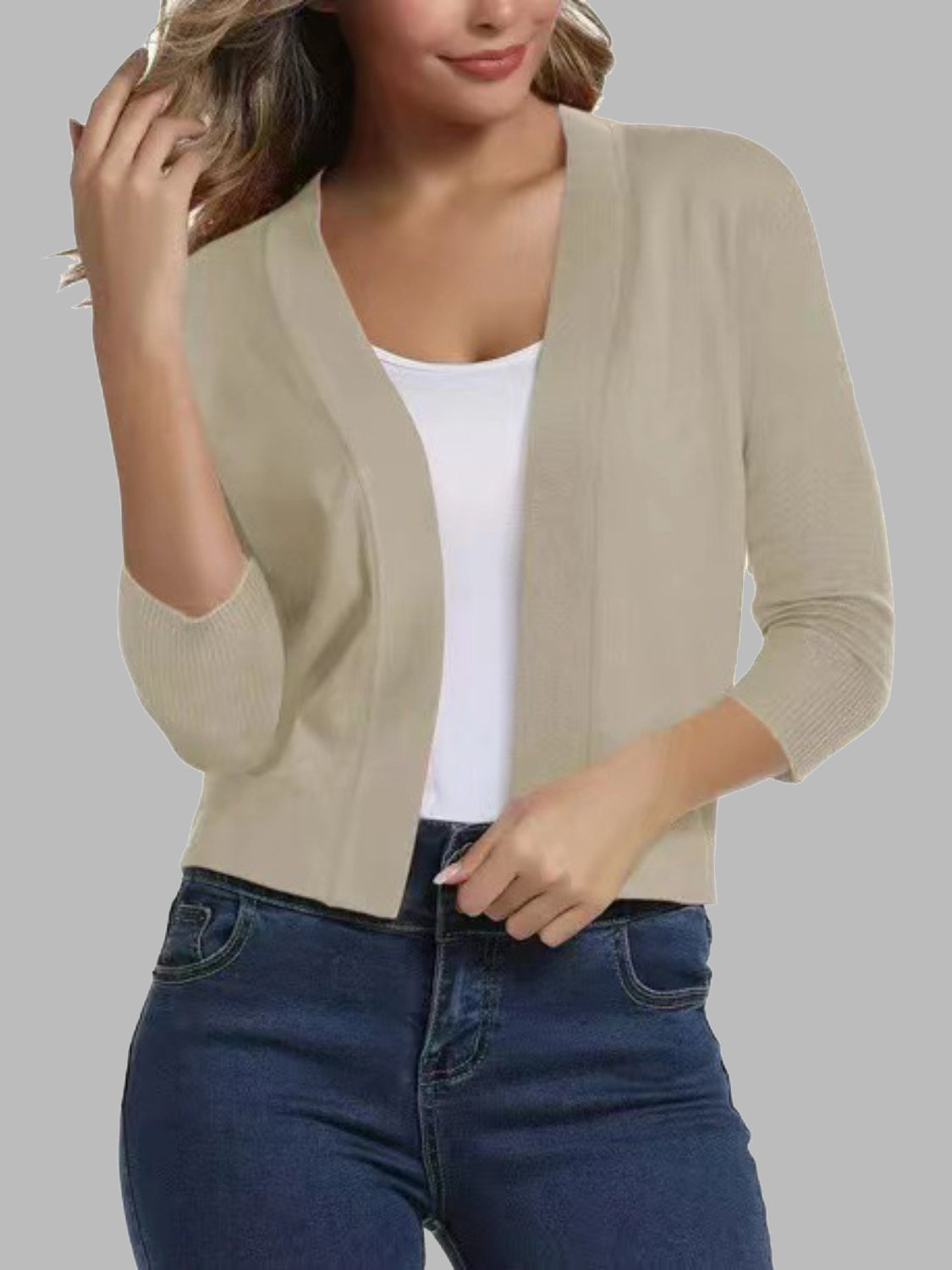 Beige cropped elbow-sleeve open-front knit cardigan with a V-neckline.