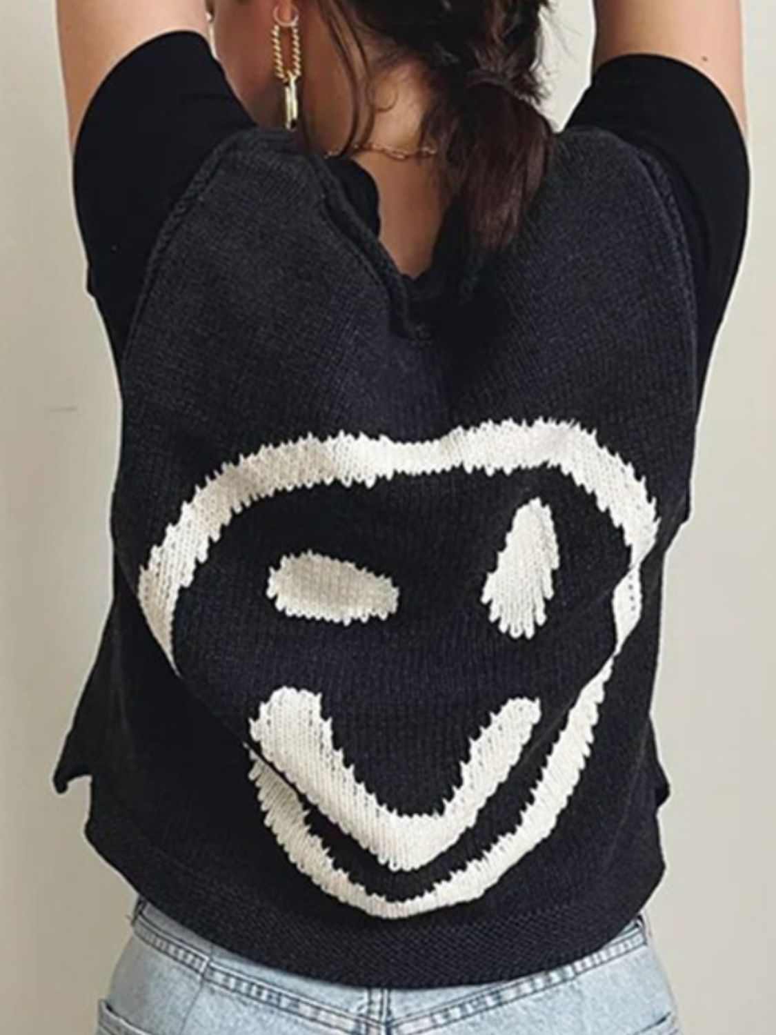 Black knit tank top with white smiley face graphic detail.