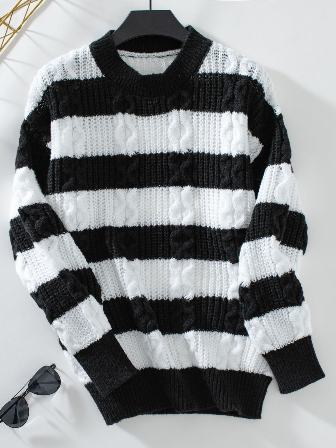 Black and white striped cable knit crewneck sweater with ribbed cuffs and hem.