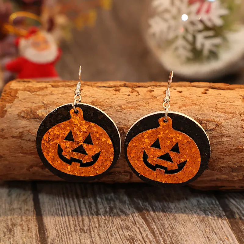 Glitter pumpkin Halloween dangle earrings in tangerine with black backing.