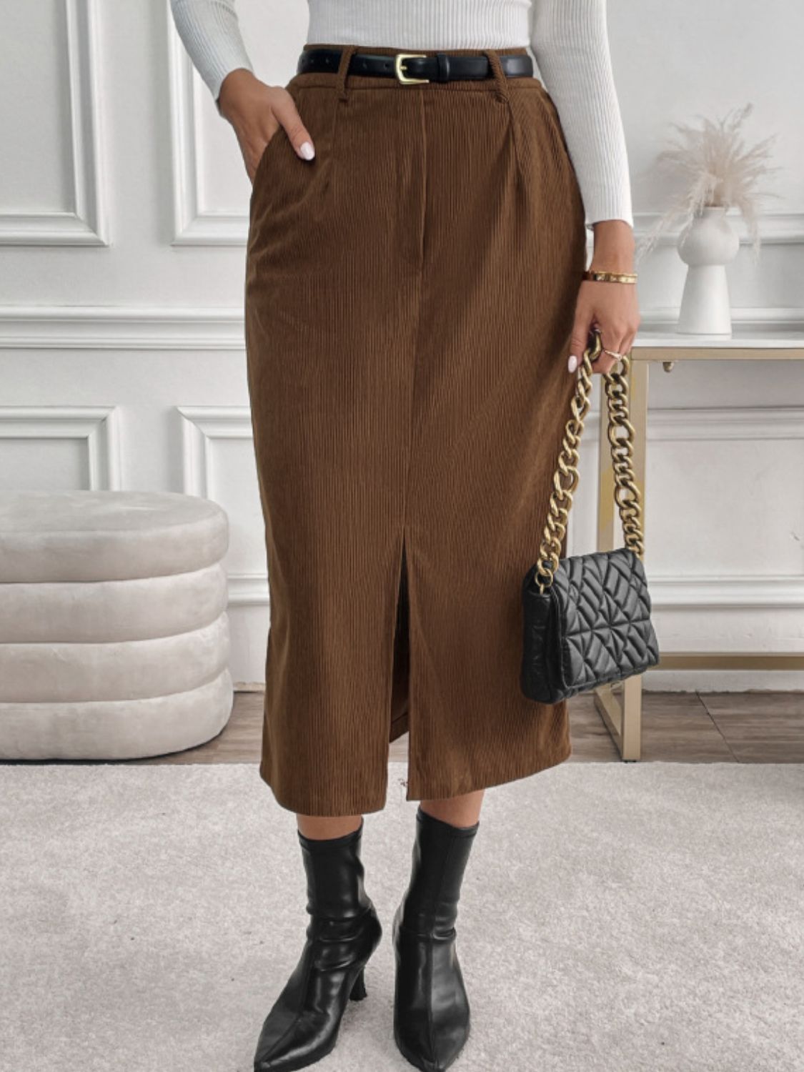 Brown corduroy midi skirt with a front slit and pockets.