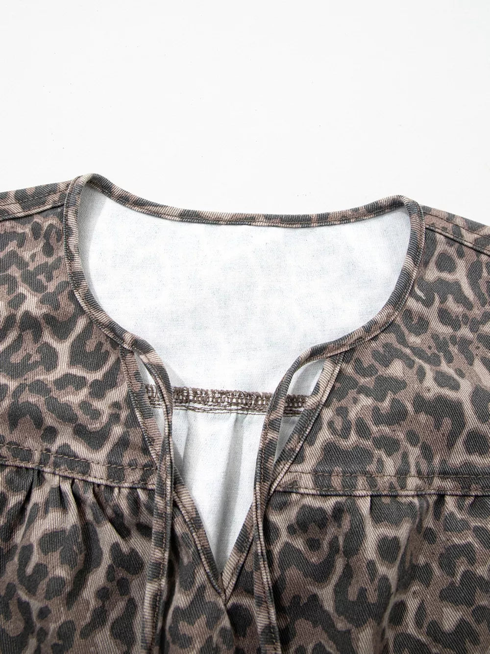Leopard print V-neck denim blouse with tie detail.