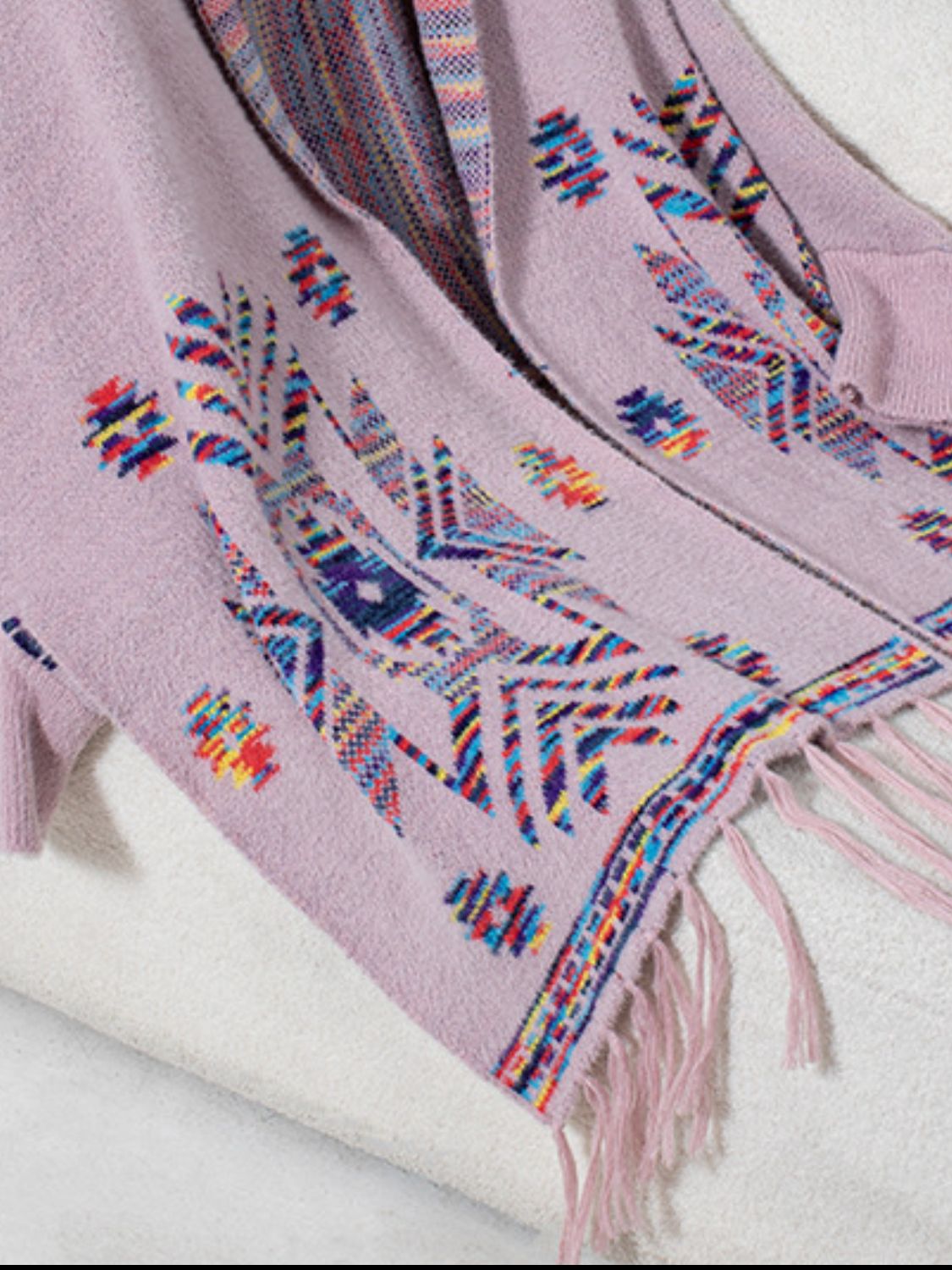 Pink purple knit cardigan with Aztec pattern, fringe trim, and colorful geometric details.