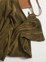 Olive green pleated two-piece set with wide sleeves and a brown crossbody bag.
