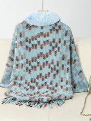 Pastel blue acrylic poncho with faux fur collar, geometric pattern, and fringe detail.