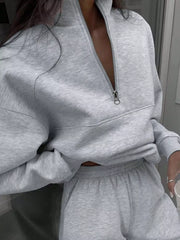 Light gray half zip sweatshirt and matching sweatpants set with a quarter zip neckline.
