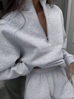 Light gray half zip sweatshirt and matching sweatpants set with a quarter zip neckline.