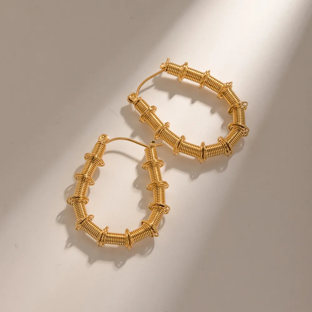 Gold coiled wire hoop earrings with textured detailing