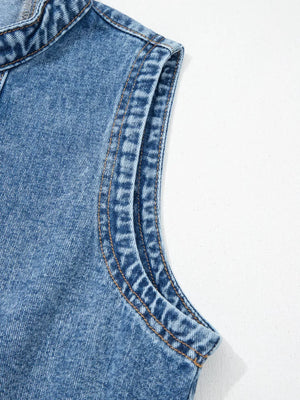 Belted denim dress detail showing contrast stitching on the sleeveless armhole and collar.
