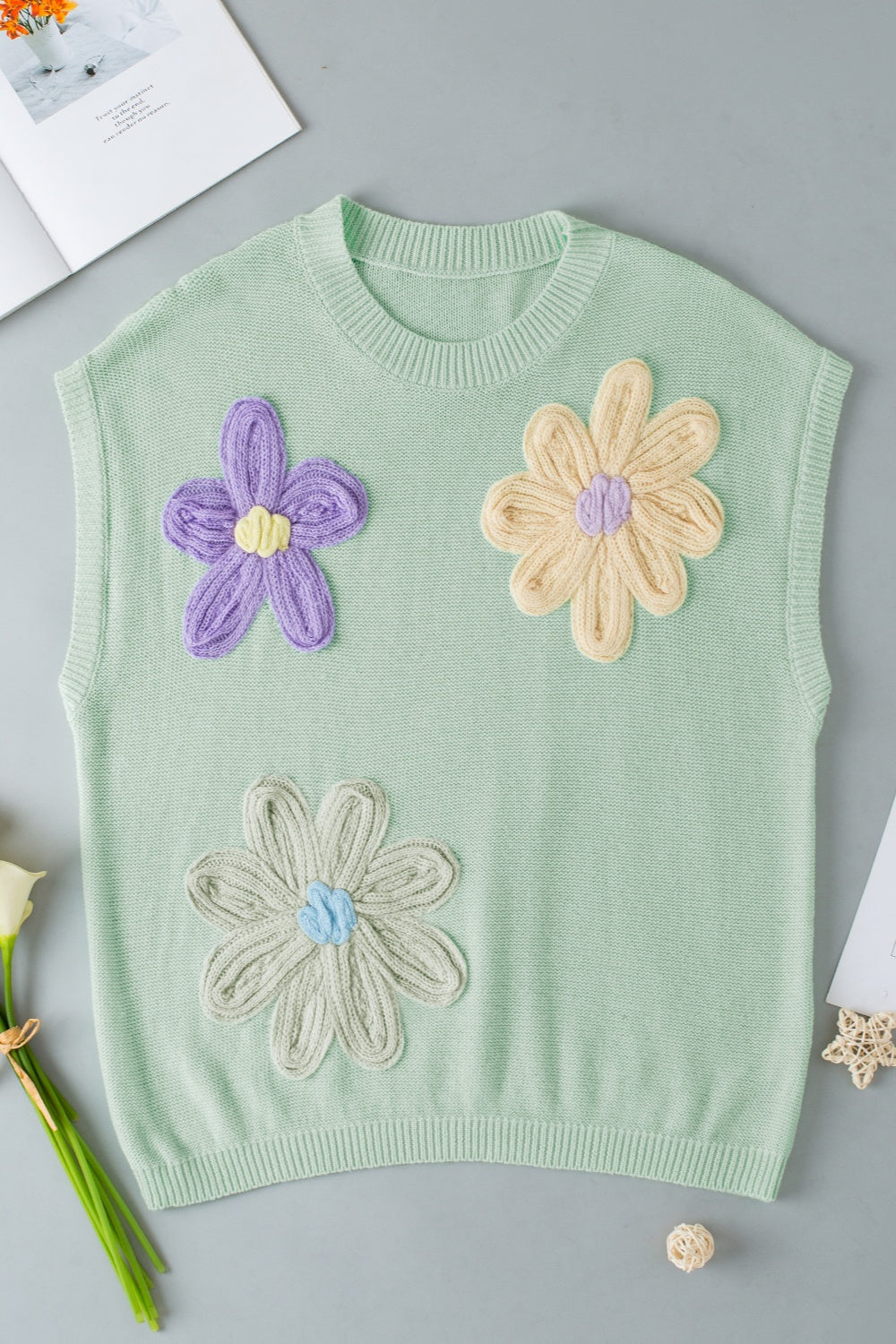 Sage knit sleeveless top with embroidered purple, yellow, and grey flowers.