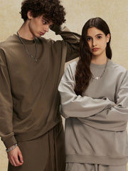 Oversized crewneck sweatshirt in light gray with subtle shoulders, crew neck, and long sleeves.