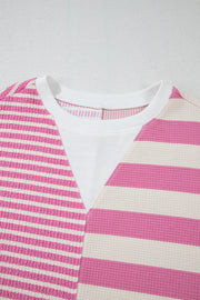 Pink and white striped waffle knit top with a white ribbed inset at the neckline.