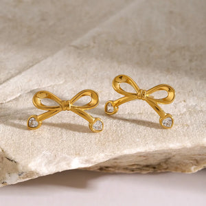 Gold bow stud earrings with cubic zirconia accents.