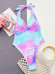 Multicolor tie-dye plunge halter one-piece swimsuit with ruched straps and a knotted tie.