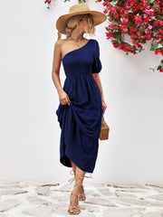 Dark blue smocked bodice one-shoulder tiered midi dress with puff sleeve.