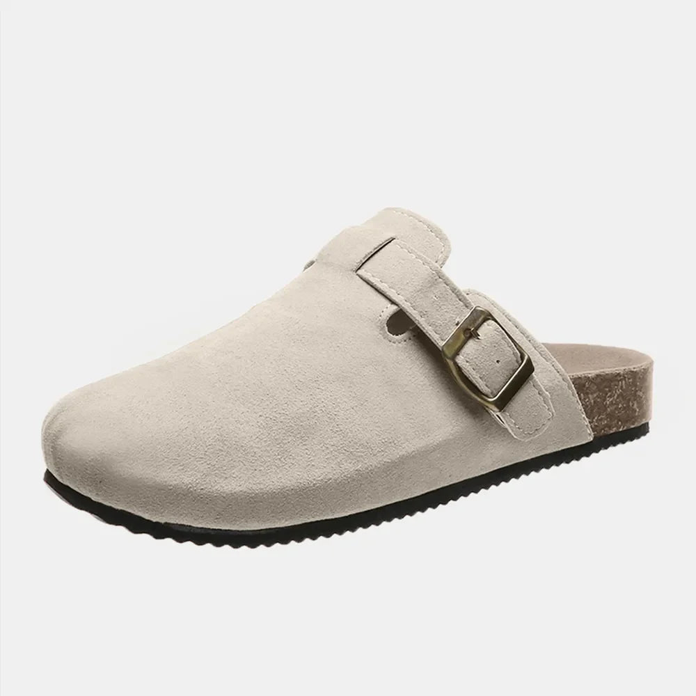 Beige suede clog slides with adjustable buckle and cork sole.