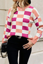 Checkerboard knit pullover sweater with crew neck and long sleeves in pink, peach, and white.