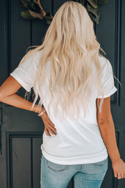 White t-shirt with cuffed sleeves and a relaxed fit, styled with jeans.