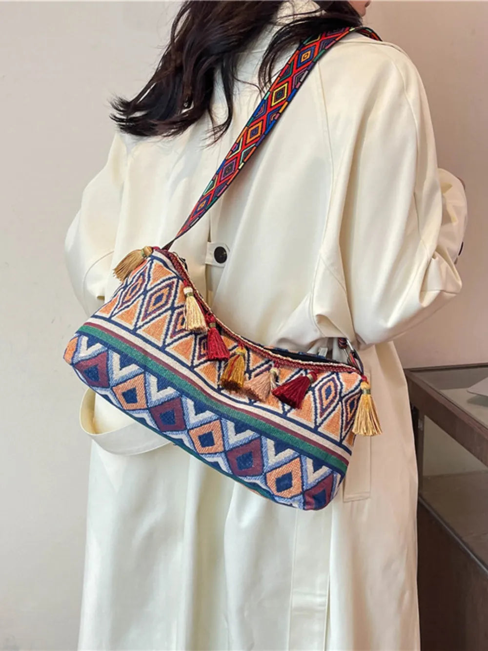 Geometric embroidered shoulder bag with tassels and colorful strap
