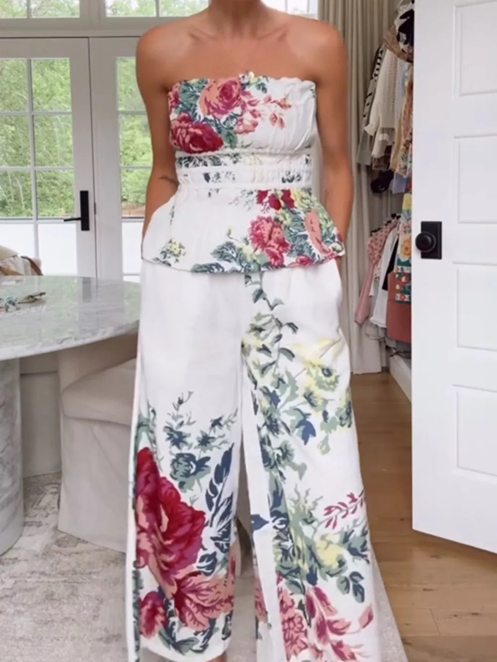 Chic floral ruched strapless top and wide-leg pants set with a white polyester base.