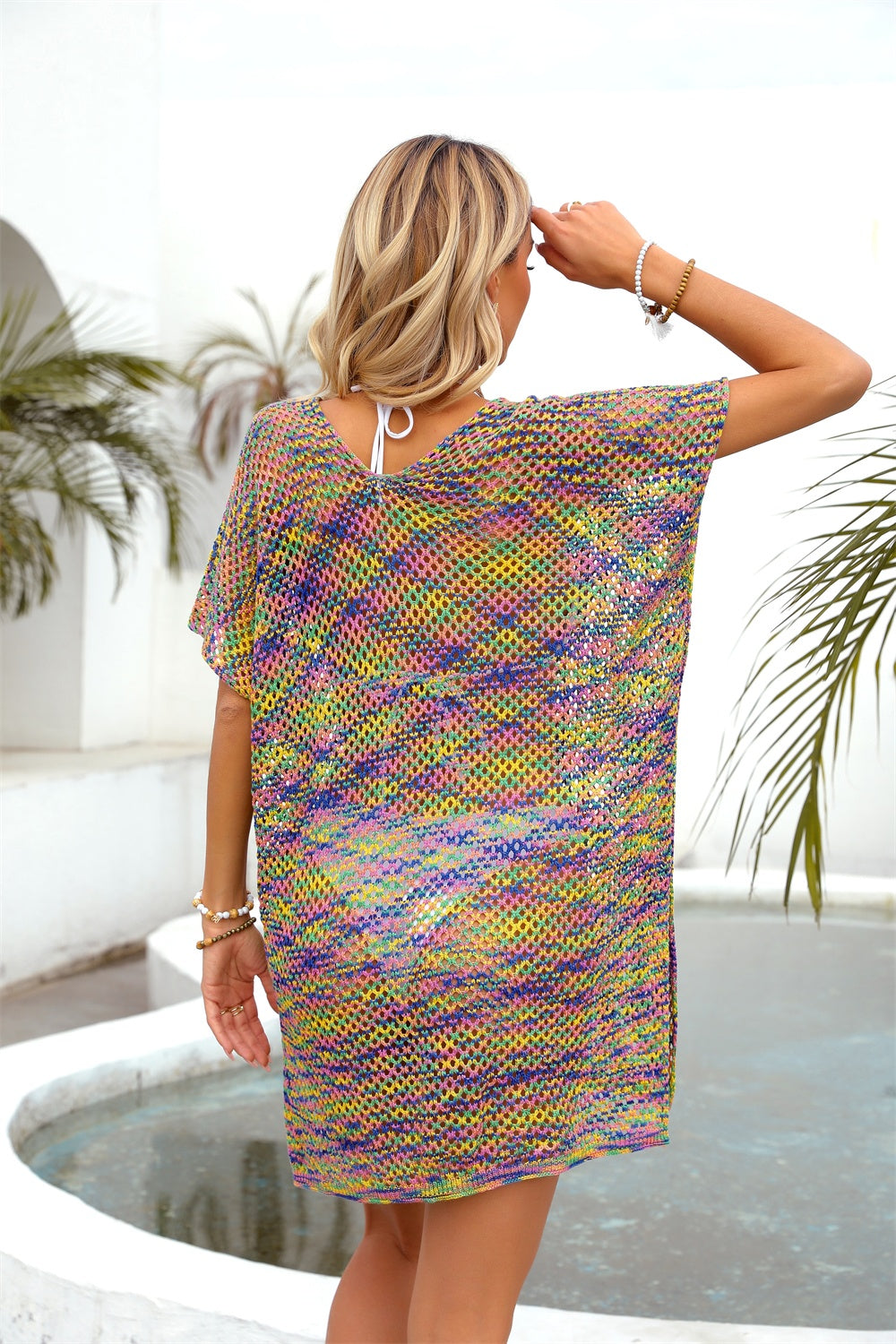 Open-knit caftan with multicolor stripes, V-neck, short sleeves, and slit hem.