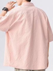 Men's pink textured short-sleeve shirt with a buttoned collar.