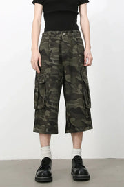 Green camouflage pleated culotte cargo shorts with buttoned flap pockets.