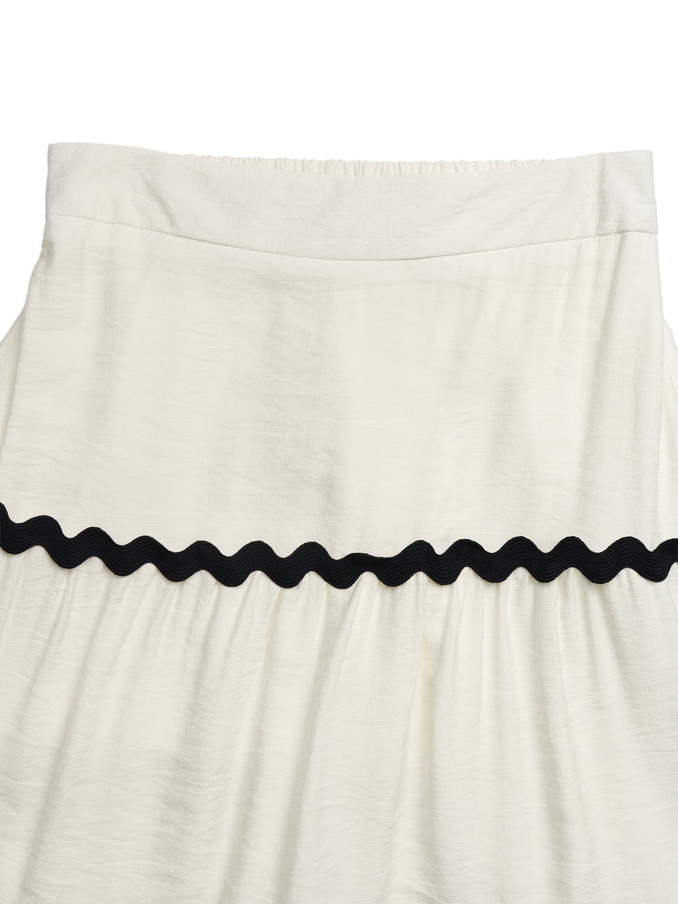 Beige tiered midi skirt with wavy black trim and textured fabric.