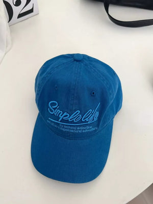 Royal blue cotton baseball hat with cursive "Simple Life" embroidery and text detail.