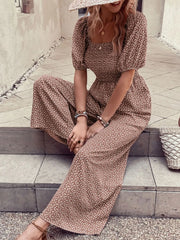 Smocked bodice floral wide-leg jumpsuit with puff sleeves and square neckline.