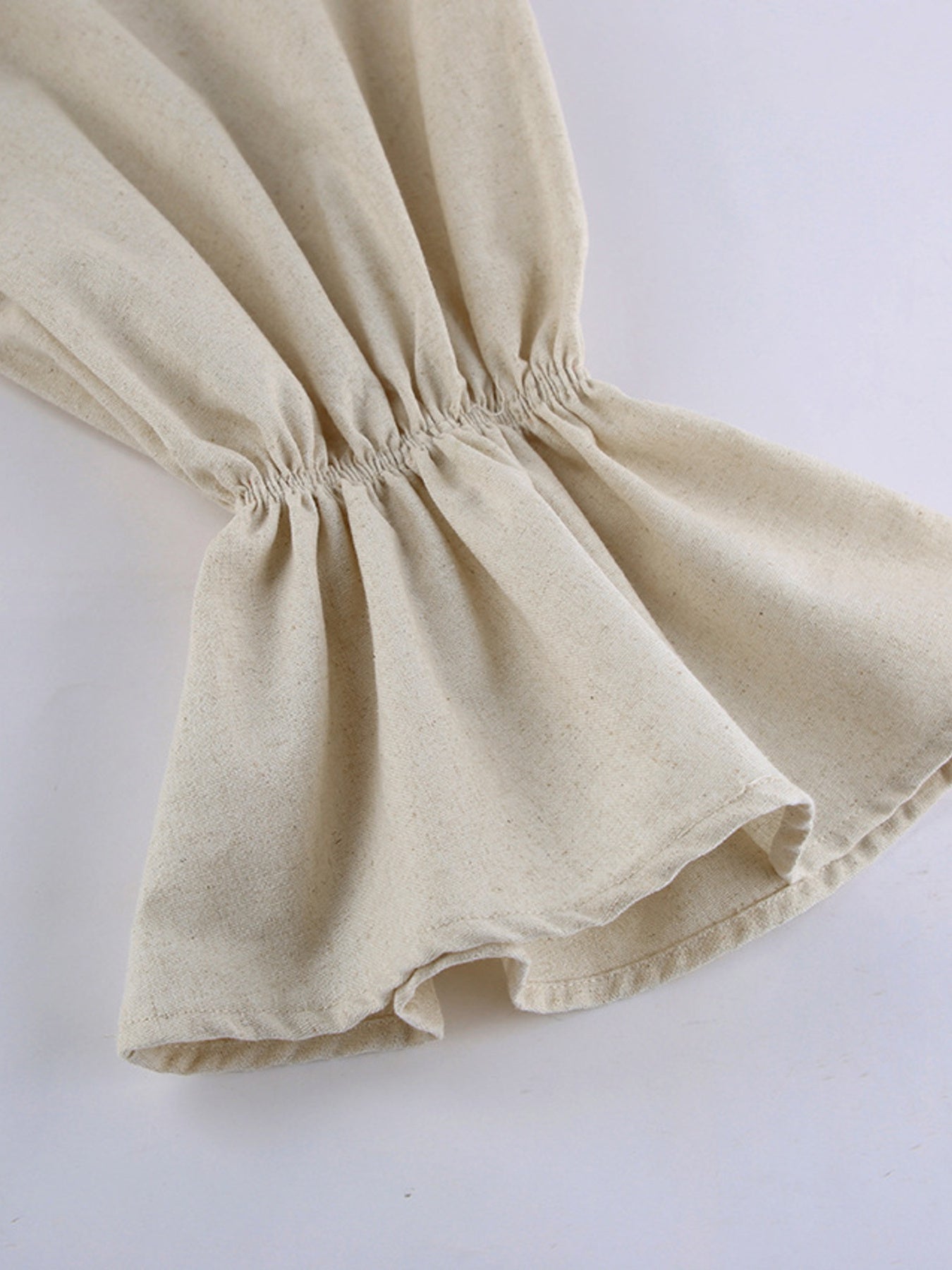 Beige cotton ruffled maxi dress with smocked detail and flared hem.