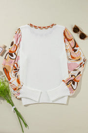 White knit sweater with scalloped neckline and colorful floral print puff sleeves.