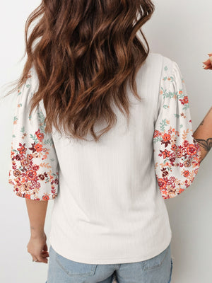 Ribbed white top with floral print half sleeves and a crew neck.
