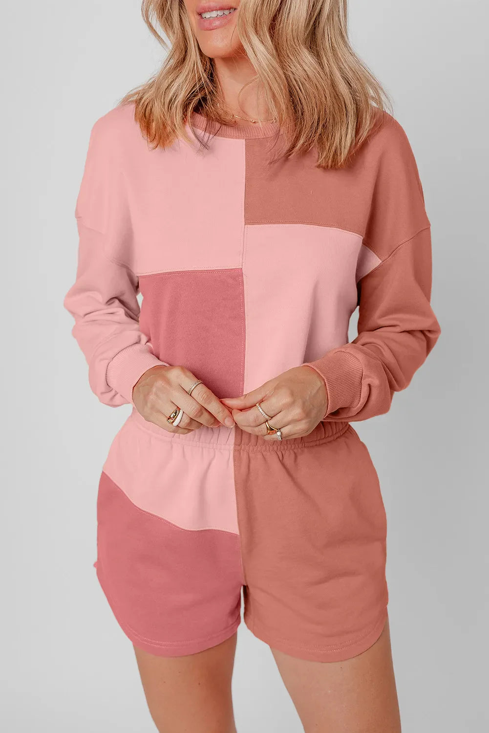 Colorblock lounge set with crewneck sweatshirt and shorts in dusty pink and light blue shades.
