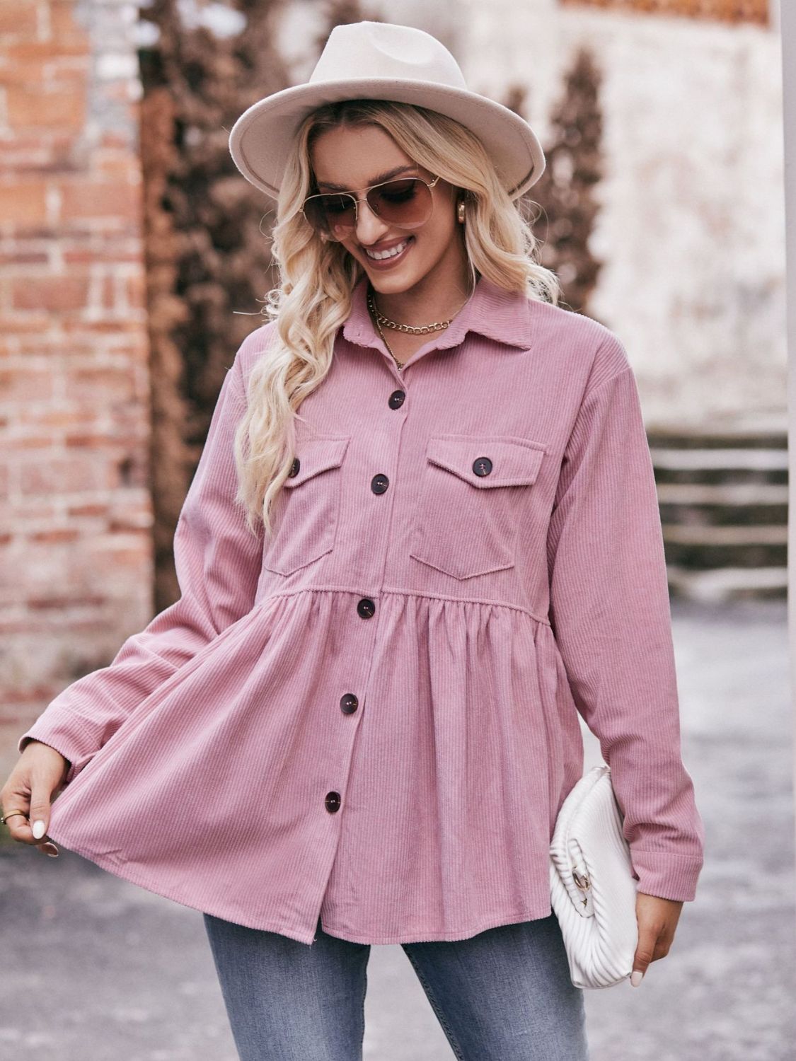 Pink corduroy peplum shirt jacket with button front and chest pockets.