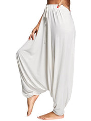 White drape-front drawstring harem pants with a relaxed fit.