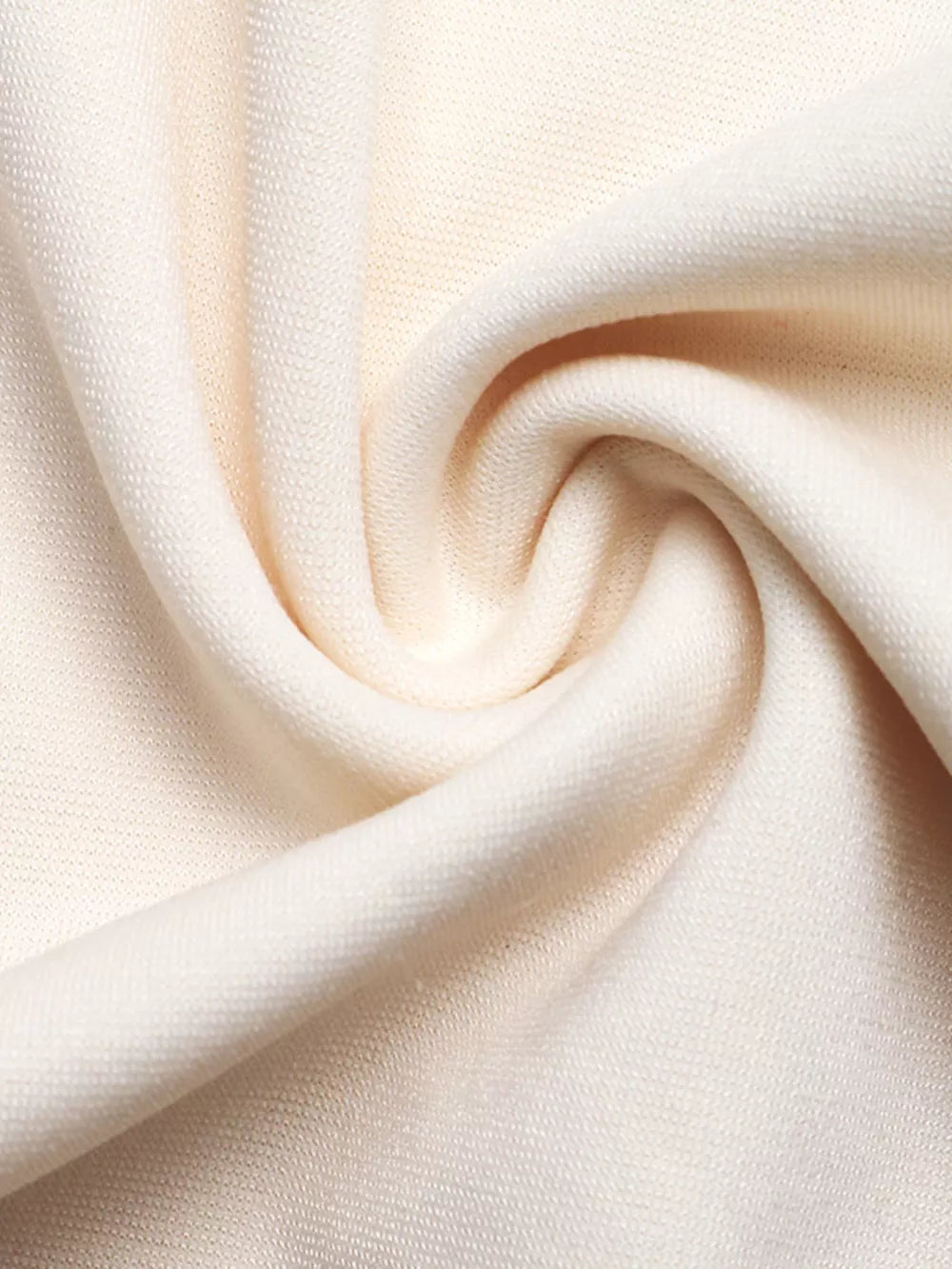 Beige textured fabric detail of a comfortable maternity jumpsuit.