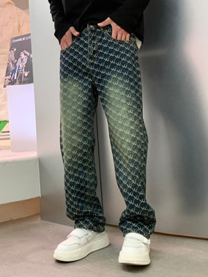 Men's relaxed fit jeans in blue denim with all-over woven motif pattern and distressed wash.