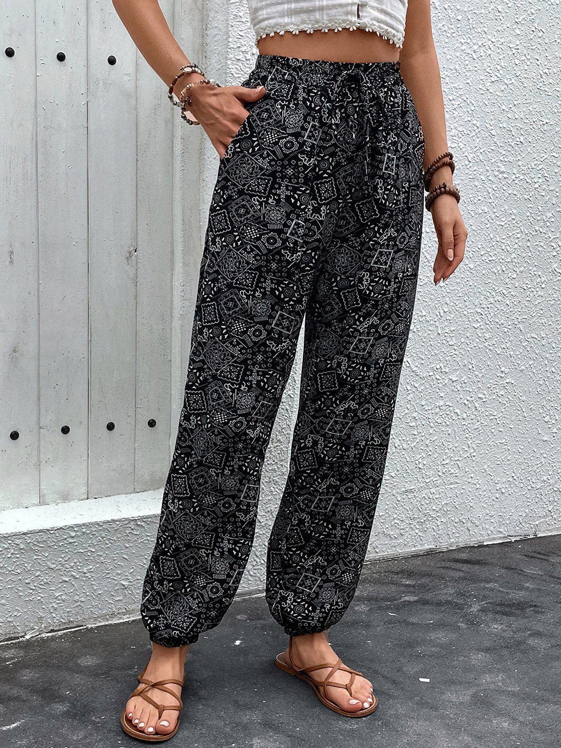 Black printed jogger trousers with gathered ankles and a drawstring waist.