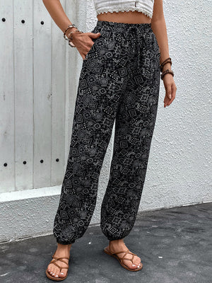 Black printed jogger trousers with gathered ankles and a drawstring waist.