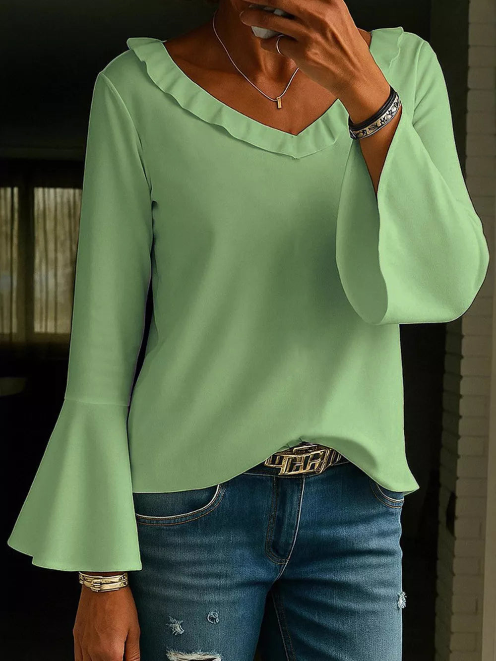 Light green polyester blouse with ruffled V-neck and bell sleeves.