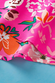 Hot pink floral blouse with smocked yoke detail and flutter sleeves.