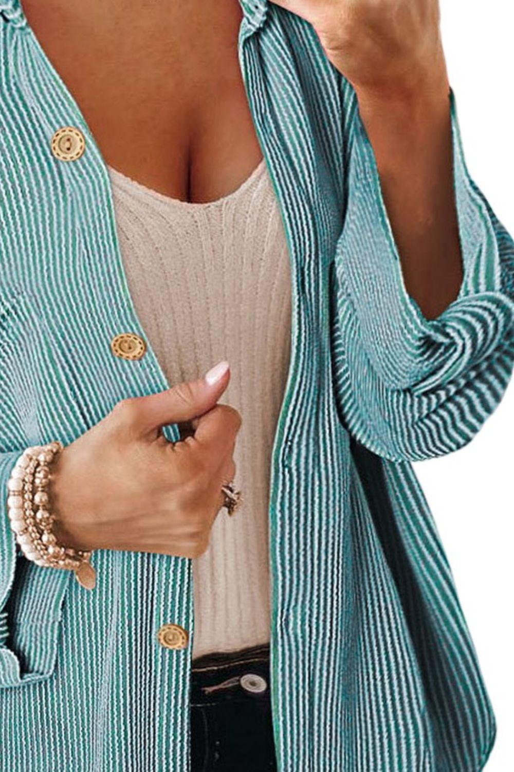 Turquoise striped overshirt with oversized fit and gold buttons, worn open over a cream tank top.
