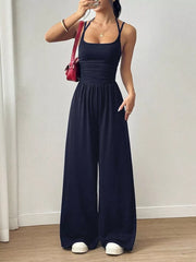 Black ruched wide-leg jumpsuit with spaghetti straps and a square neckline.
