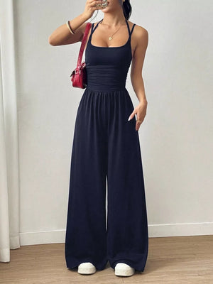 Black ruched wide-leg jumpsuit with spaghetti straps and a square neckline.